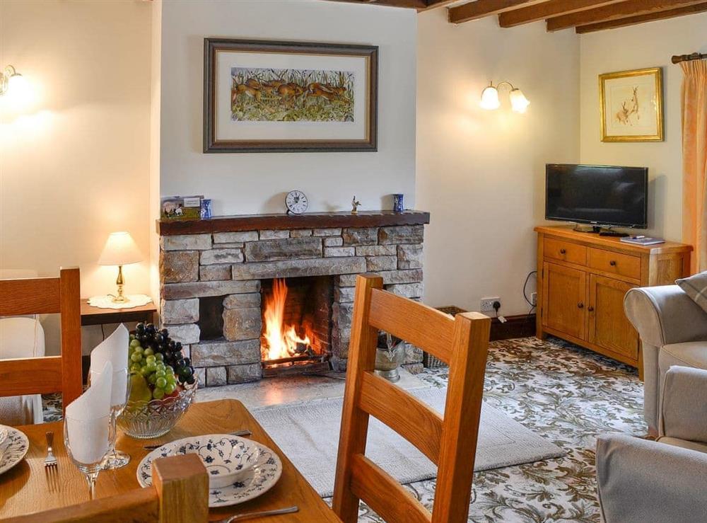 Living space with open fireplace at Swaledale Cottage in Caldbeck, near Keswick, Cumbria