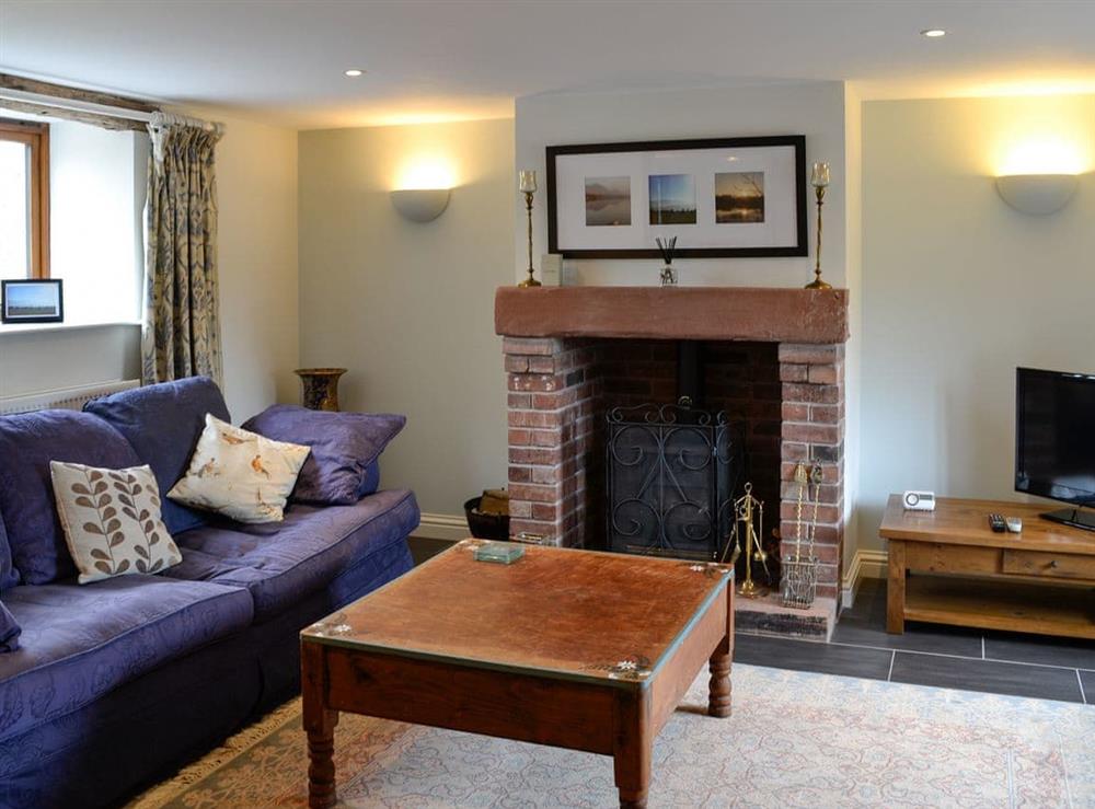 Cosy living room with wood burner at Swallow Barn in Torpenhow, near Wigton, Cumbria