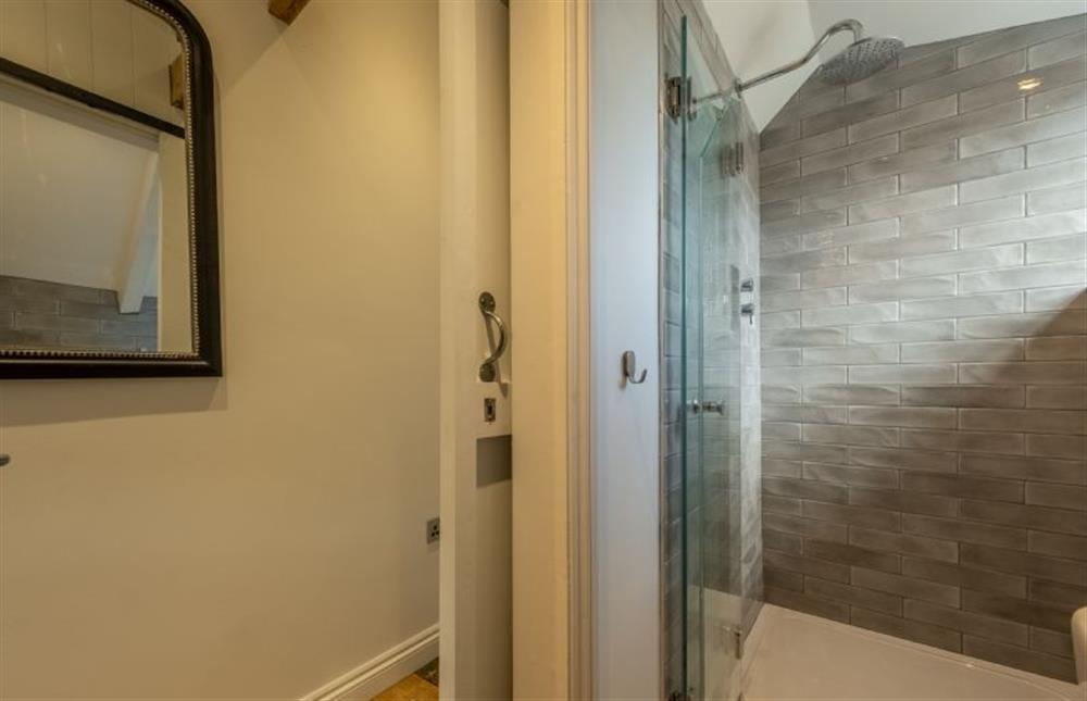 A sliding door opens to a second shower room at Swallow Cottage, Binham near Fakenham