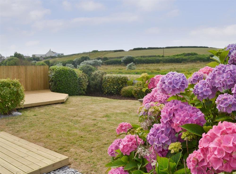 Enclosed garden with decked patio area and lovely rural views at Swallows Nest in Bude, Cornwall