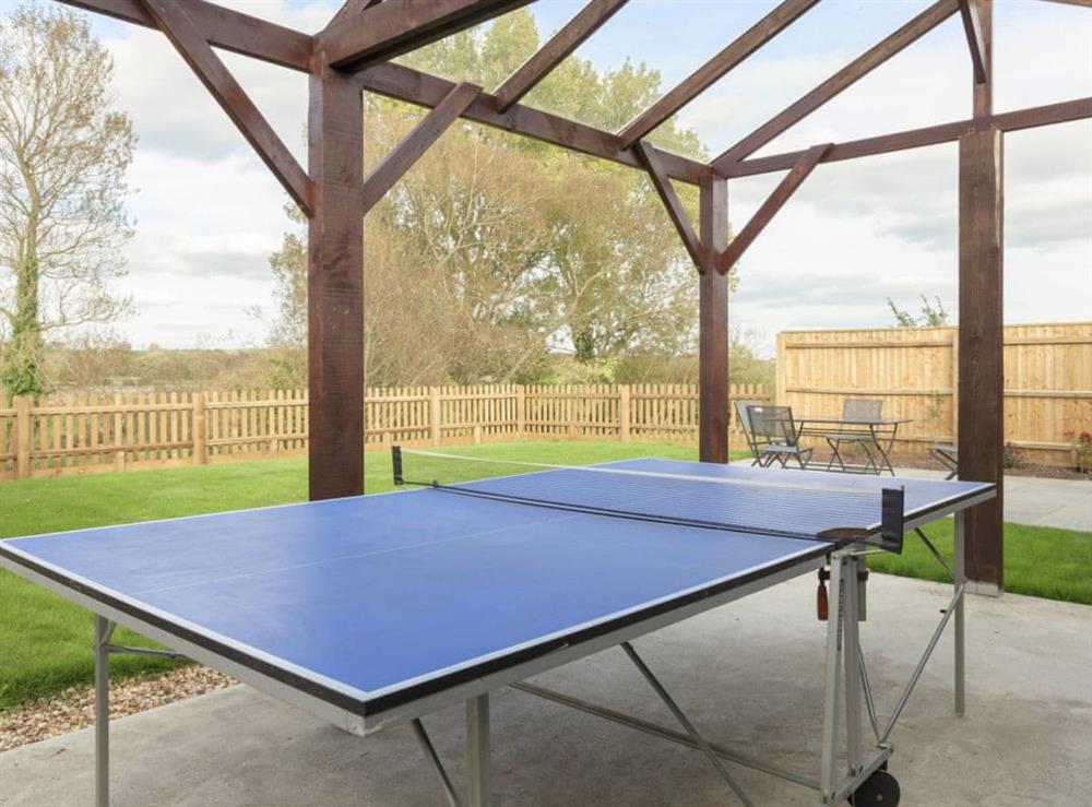 Spacious enclosed garden with patio area and table tennis at Swallows Nest in Wool, near Wareham, Dorset
