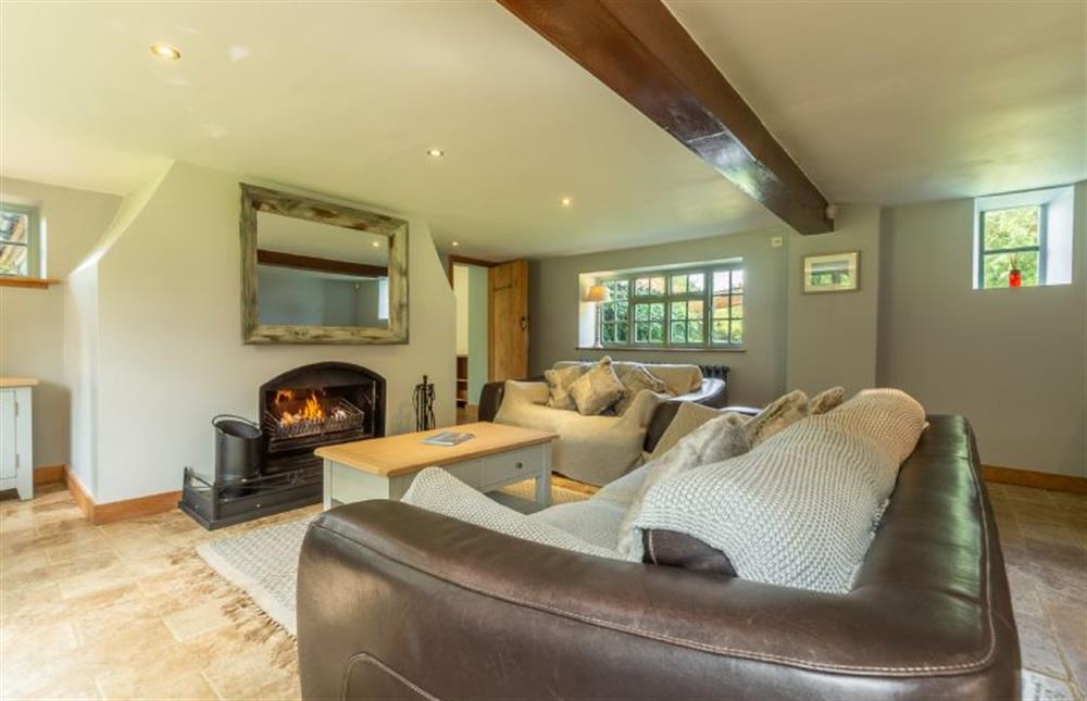 Swan Cottage: Sitting room featuring a log burner and comfy seating  at Swan Cottage, South Creake near Fakenham