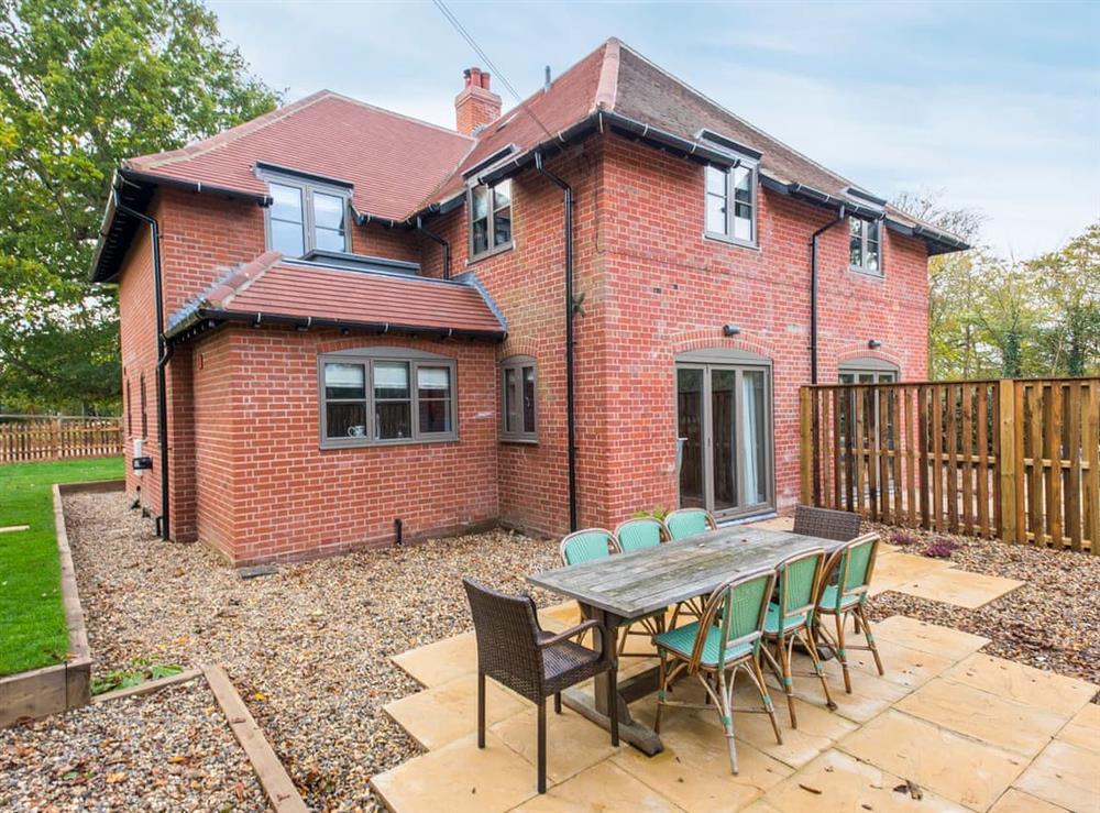 Enclosed lawned garden with patio and garden furniture at Cowslip Cottage, 