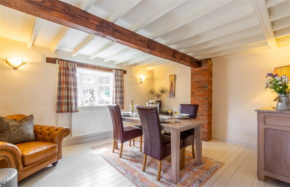 Ground floor:  Dining room with beamed ceiling and comfy armchair at Swift Cottage, Dersingham near Kings Lynn