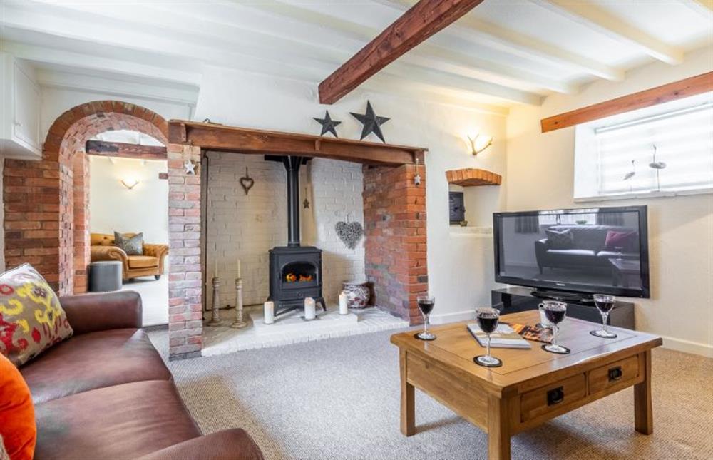 Ground floor:  Sitting room with feature fireplace and wood burning stove at Swift Cottage, Dersingham near Kings Lynn