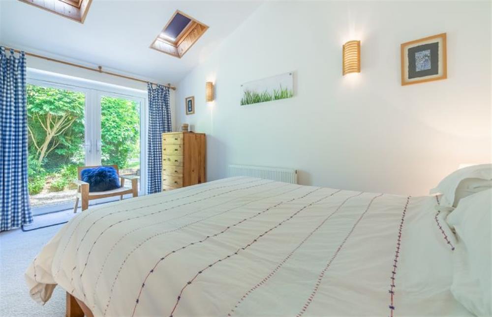 Ground floor: Bedroom two with King-size bed and french doors into the garden at Sybil Cottage, Holme-next-the-Sea near Hunstanton