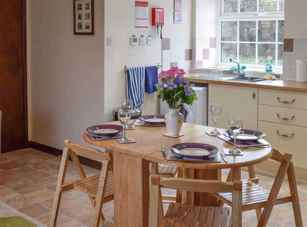 Open plan living area with modest dining table and chairs at Sycamore Cottage in Borrowby, near Staithes, North Yorkshire