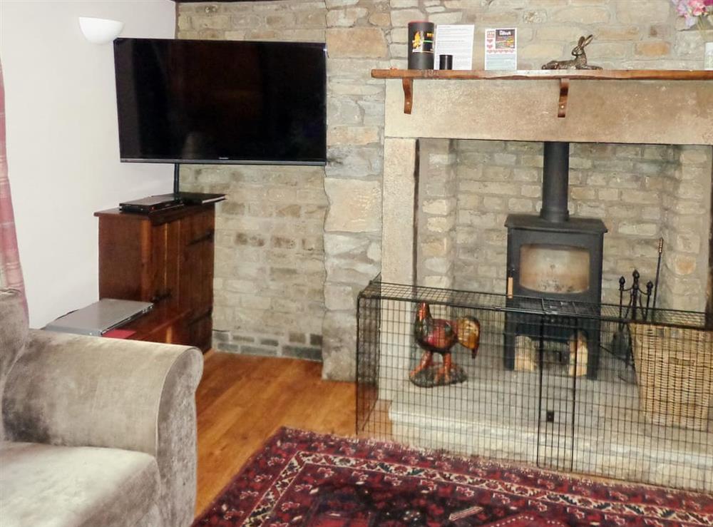Cosy country living room with beamed ceiling and woodburner at Sycamore Cottage in Skipton, North Yorkshire
