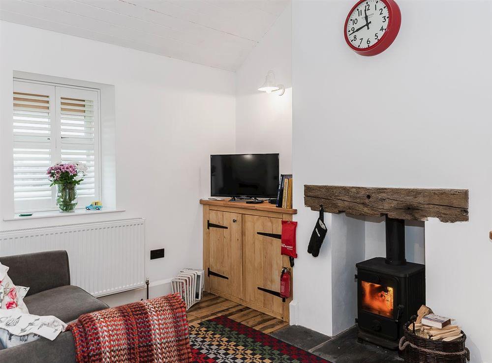 Attractive comfortable open plan living/dining room and kitchen with wood burning fire at Tŷ Macsen, 