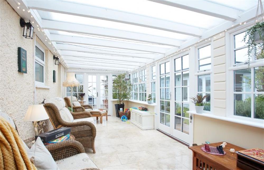 Tamarisk House, Cornwall: Conservatory with rattan seating overlooking the rear garden at Tamarisk House, Newquay