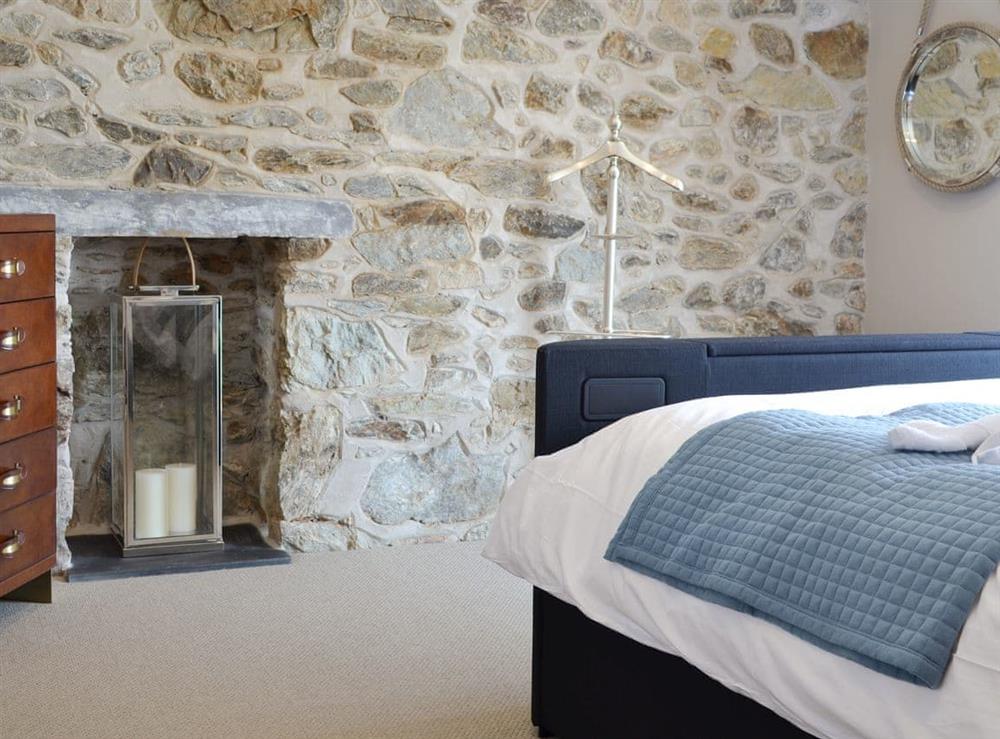 Exposed stone feature wall in the double bedroom at Tan Y Fford in Glyngarth, near Beaumaris, Anglesey, Gwynedd