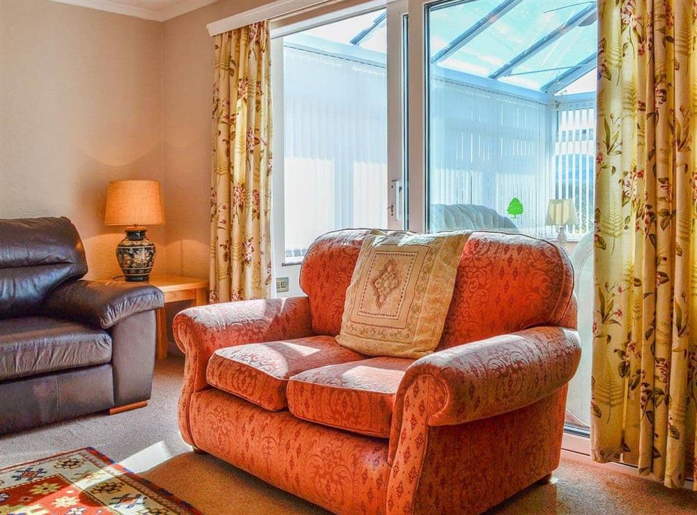 Living room with doors to the conservatory at Tan Y Fownog in Penrhyndeudraeth, Gwynedd