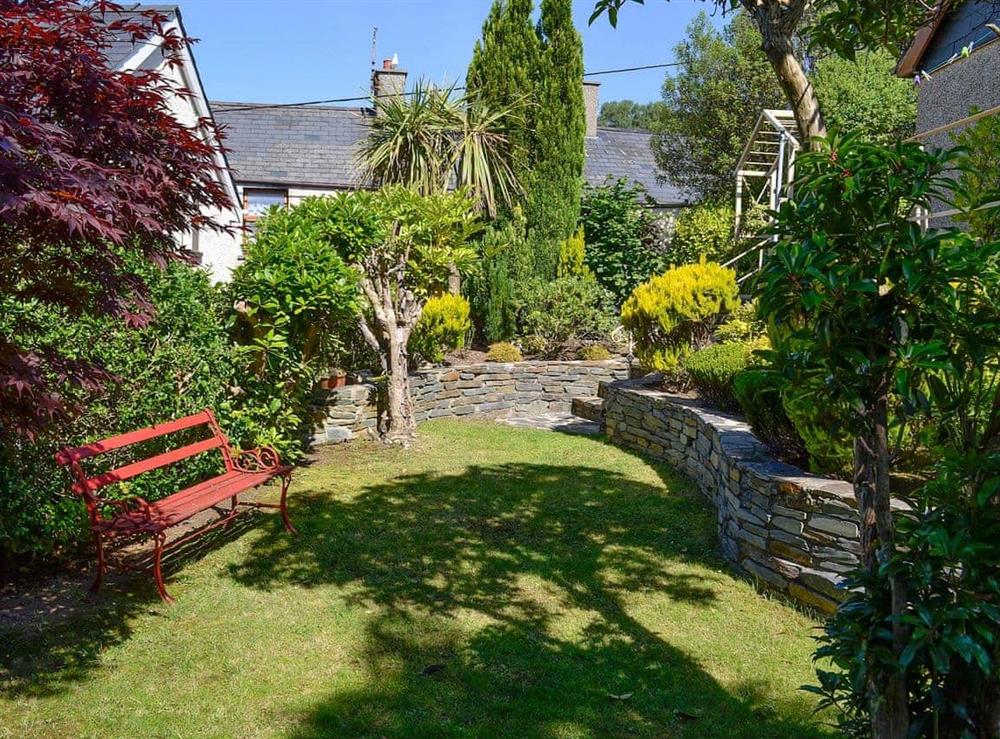 Lovely leafy garden with seating areas at Tan Y Fownog in Penrhyndeudraeth, Gwynedd