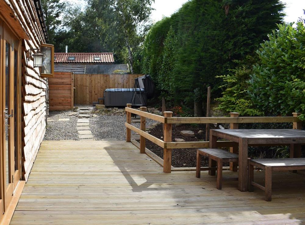 Decked area with seating for alfresco entertaining at Poppy Lodge, 