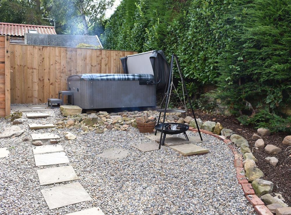 Gravelled area with hot tub and fire cauldron at Poppy Lodge, 