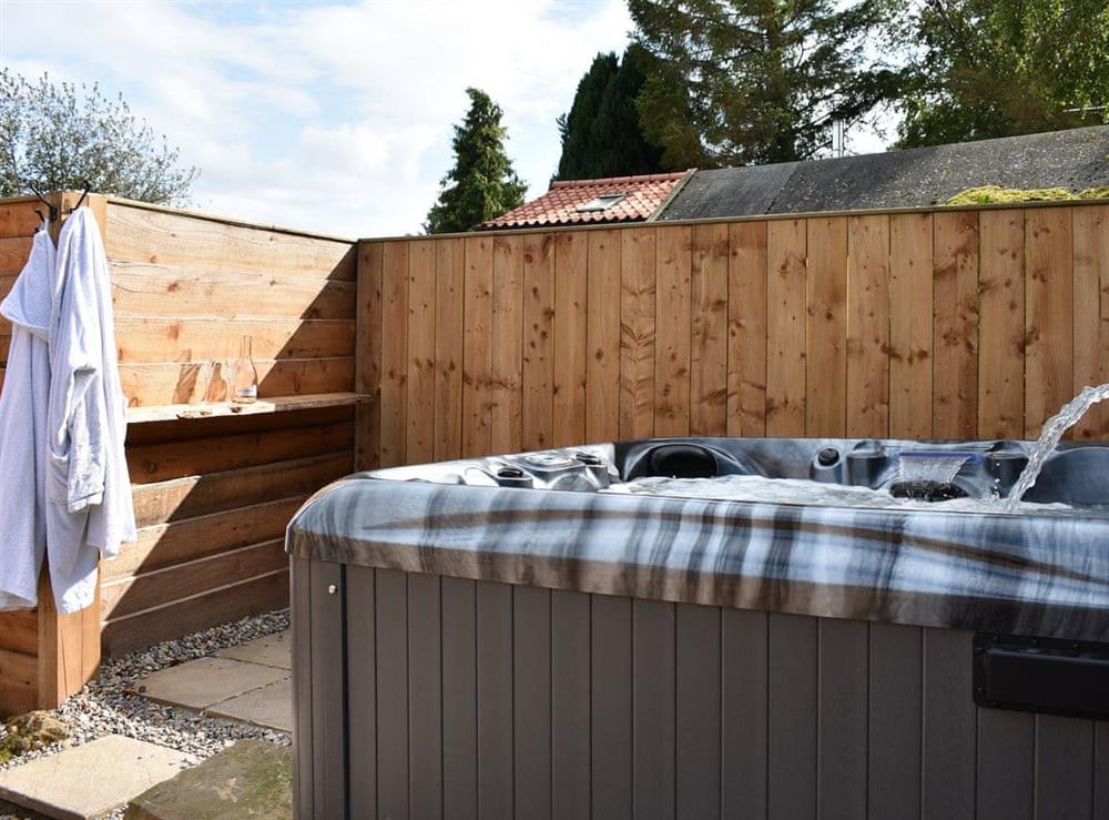 Relax in the luxurious hot tub at Poppy Lodge, 
