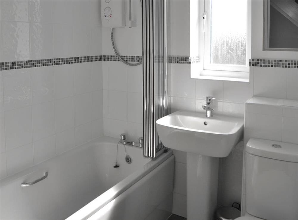 Bathroom with shower over bath, and toilet at Teal House in Amble, Northumberland