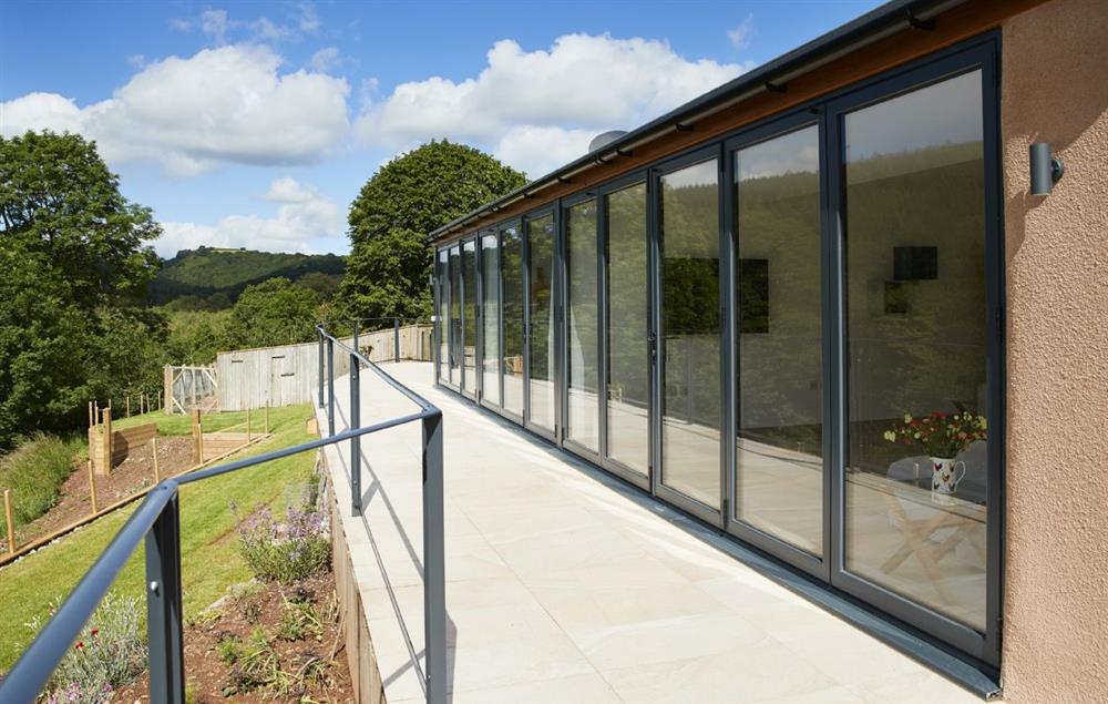 A staggering 16 metres of bi-fold doors opening out to a tiled balcony overlooking the beautiful river