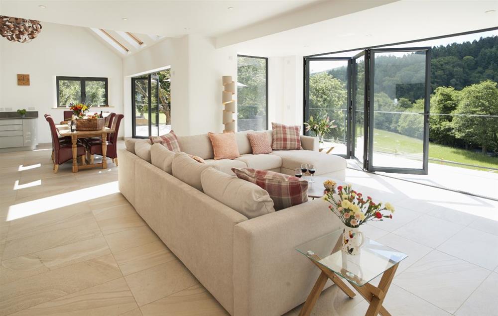 The spacious open plan sitting room with beautiful oak dining table seating eight guests at Teign Vale, Drewsteignton