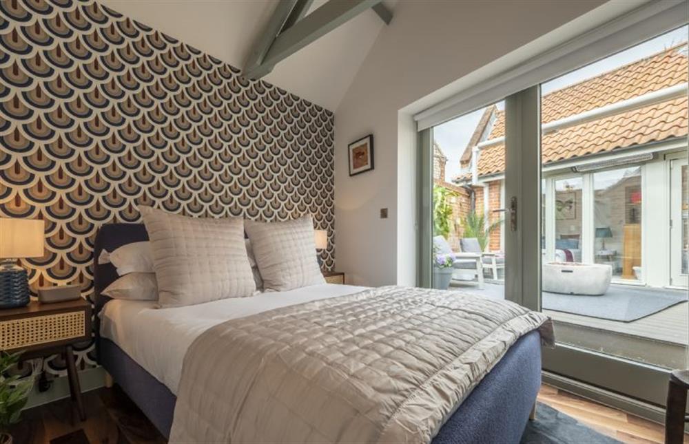 Bedroom four with double bed and doors to the garden at Tern Cottage, Burnham Market near Kings Lynn