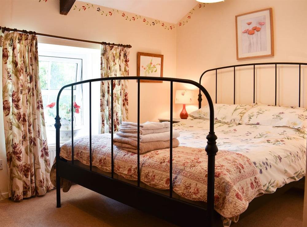 Double bedroom with antique style bed at Tetheran Cottage in Marrick, near Reeth, North Yorkshire