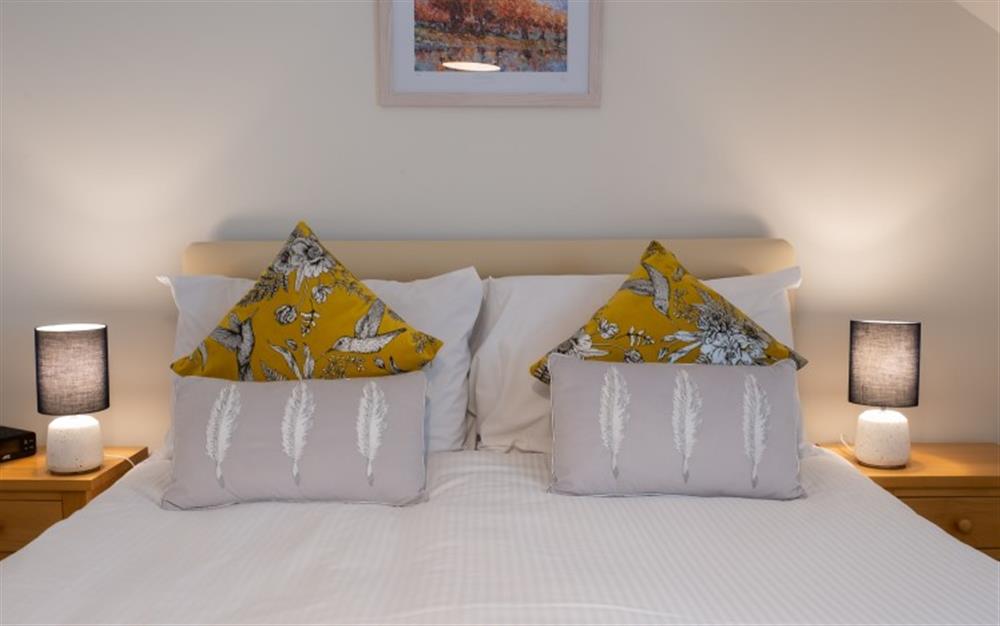The coloured cushions add a pop of colour to the neutral tones in the master bedroom. at Teylu in Maenporth