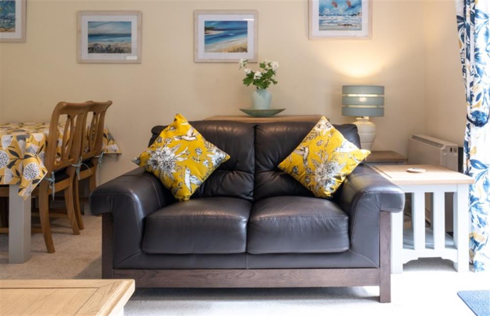 The navy leather sofa and the yellow cushions look great together. at Teylu in Maenporth