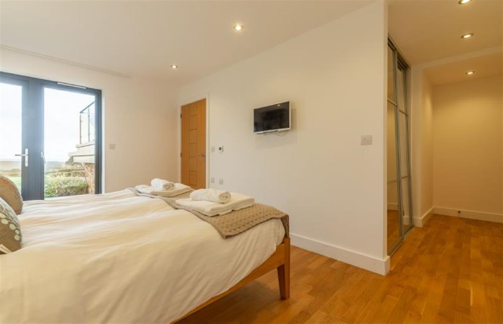 Bedroom one with king-size bed, sea views and french doors to deck (photo 2) at Teyr Mor Cliff, Chapel Porth, St Agnes