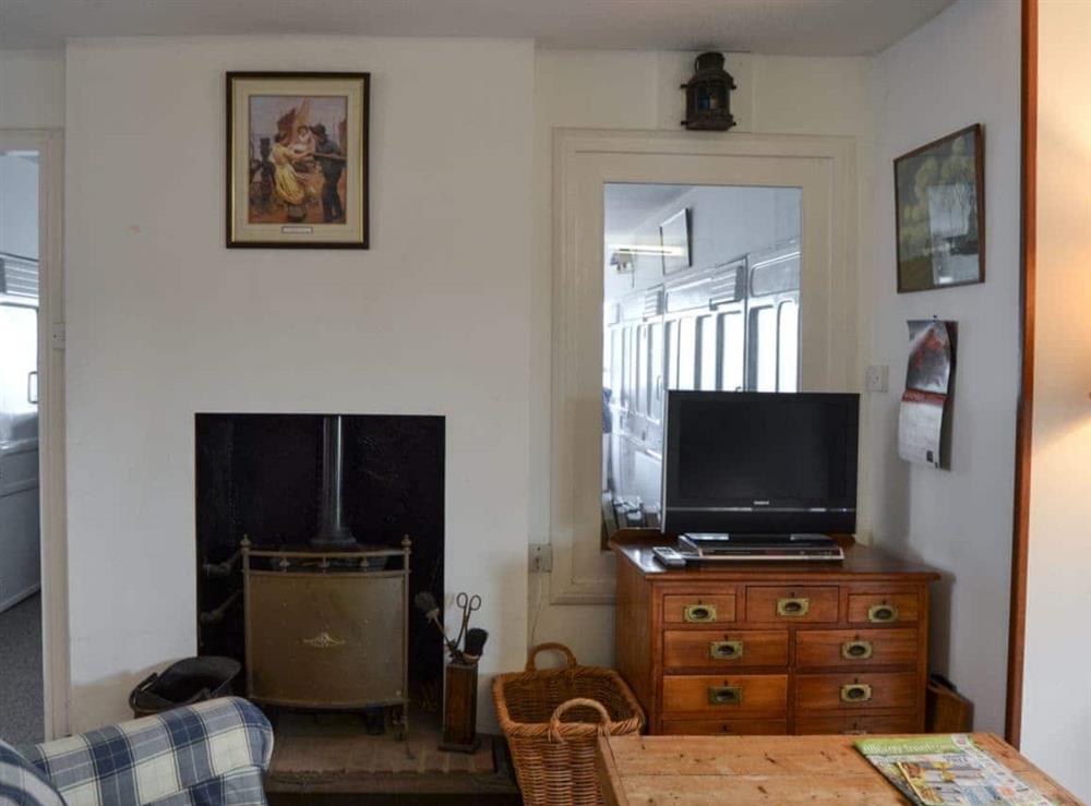 Living room with wood burner at Thalassa in Pagham, near Chichester, West Sussex