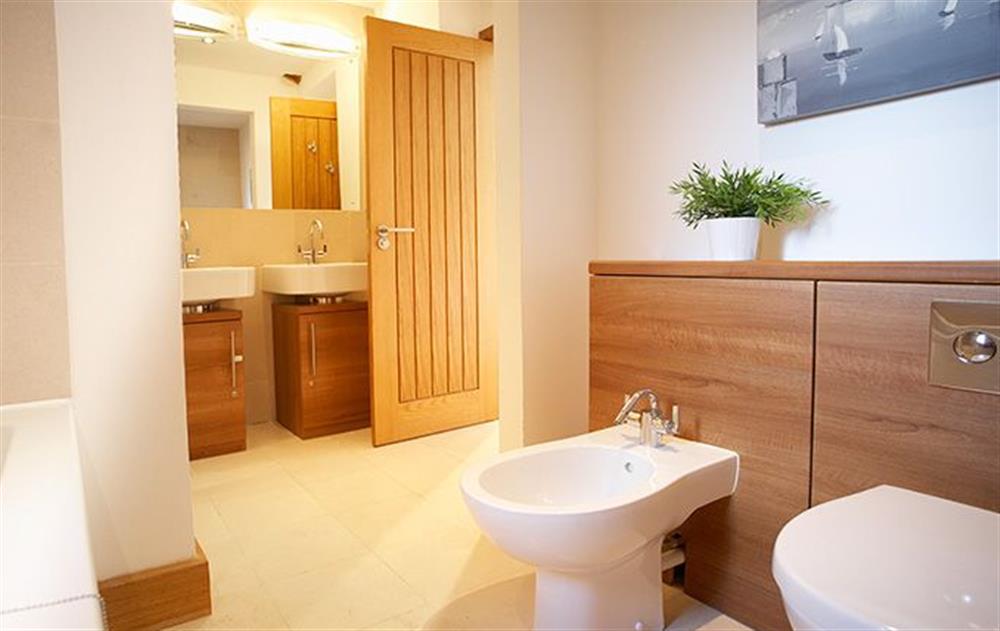 Ground floor:  Bathroom with shower over bath at Thatch Barn, Buringham Green