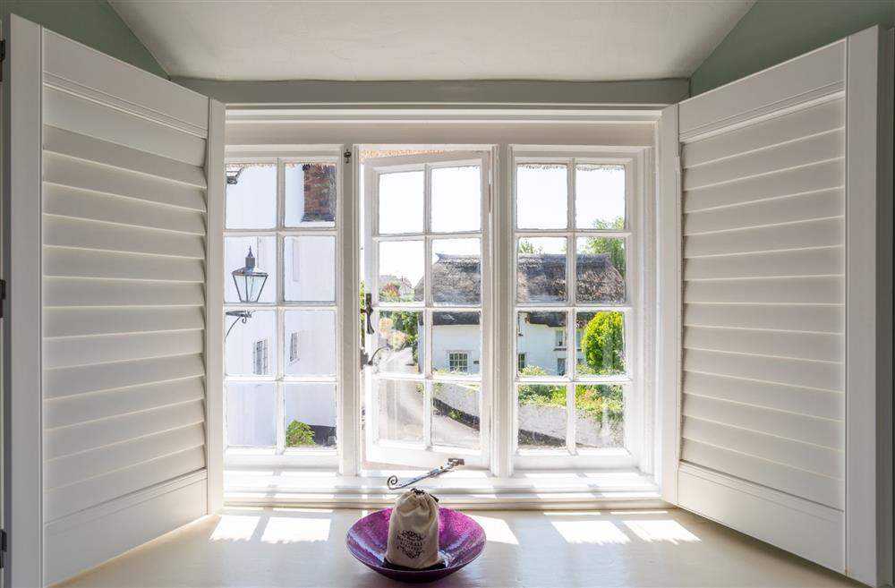 A window with shutters overlooking the quaint village