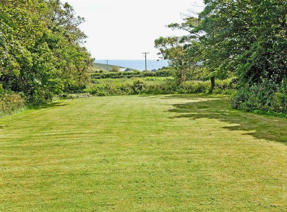 Large enclosed lawned garden with beautiful sea views at Thatch Cottage in Rosudgeon, near Marazion, Cornwall