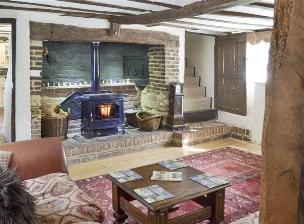 Characterful living area with wood burner in feature fireplace at Thatched Cottage in Steven’s Crouch, near Battle, East Sussex
