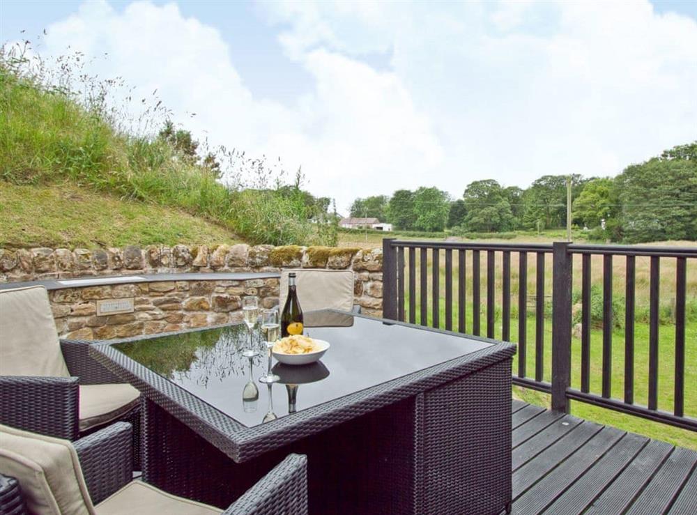 Relax on the decked patio with furniture at The Barn in Brampton, Cumbria