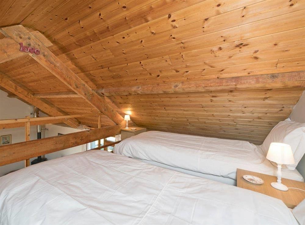 Comfortable Galleried bedroom with twin beds and beams at The Barn by The Lake in Brompton Regis, near Dulverton, Somerset