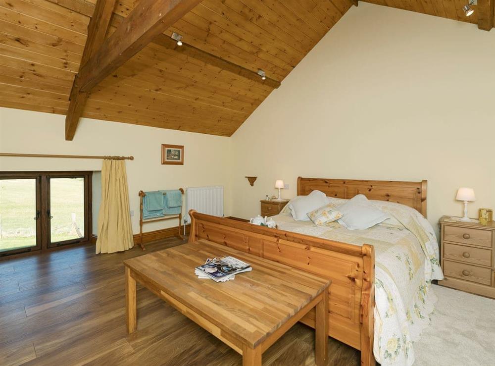 Spacious double bedroom with kingsize bed at The Barn by The Lake in Brompton Regis, near Dulverton, Somerset