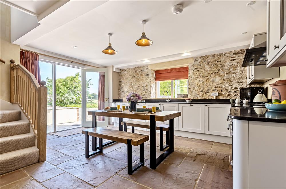 The dining kitchen is bright and airy with french doors offering views of the garden to the front at The Barn, Chard, West Dorset