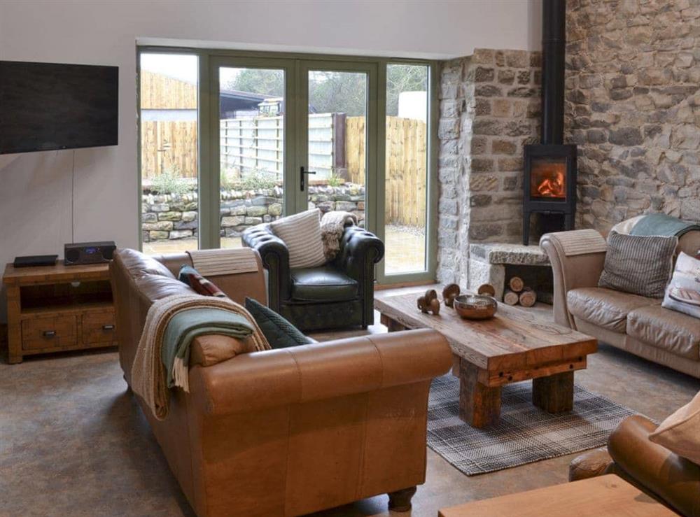 Living room with wood burner & French doors leading to garden at The Barn in Harwood Dale, near Scarborough, North Yorkshire