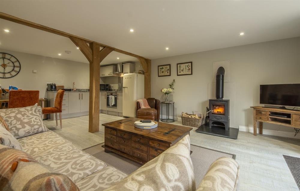The Woodshed ground floor: Open plan living area with comfortable seating and a wood burning stove (photo 3) at The Barns at Green Valley Farm, Ubbeston