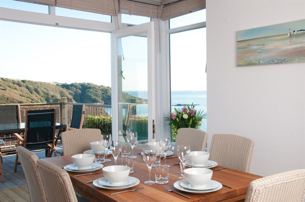 The dining area has an oak table and chairs, and lovely views at The Beach House (Woodside) in Bennett Road, Salcombe