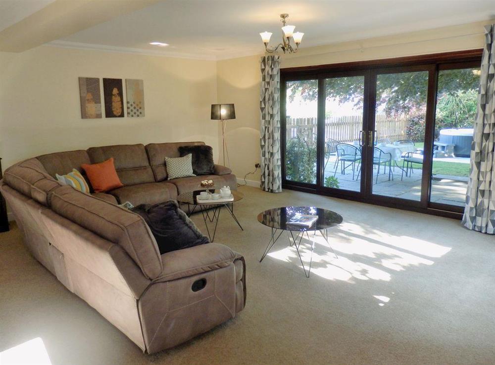 Spacious living room with patio doors to garden at The Beech House in Corton, near Lowestoft, Suffolk