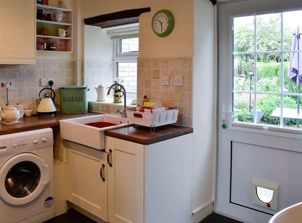 Kitchen with laundry facilities and garden access at The Bellringers Cottage in Llandegla, near Wrexham, Denbighshire
