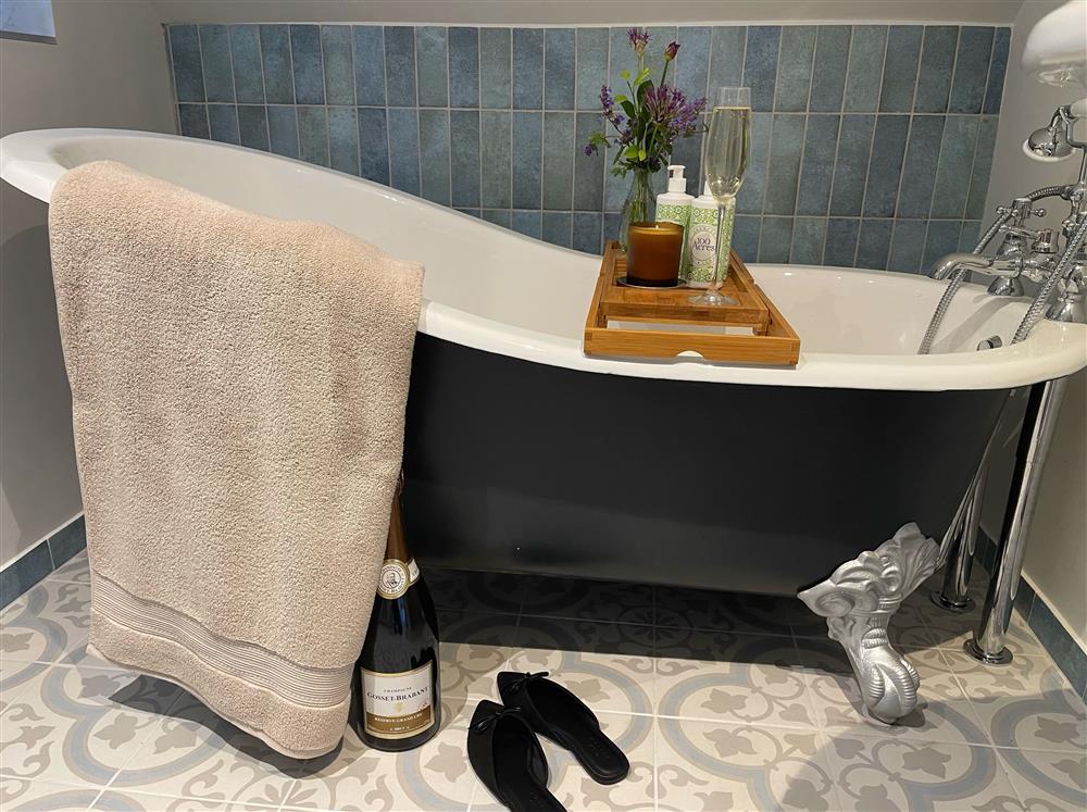 Bedroom four’s en-suite bathroom, with a beautiful roll-top bath at The Big Barn, Walton, Near Stratford-upon-Avon