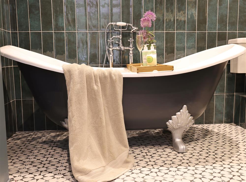 Relax in the beautiful roll-top bath in bedroom one’s en-suite bathroom at The Big Barn, Walton, Near Stratford-upon-Avon