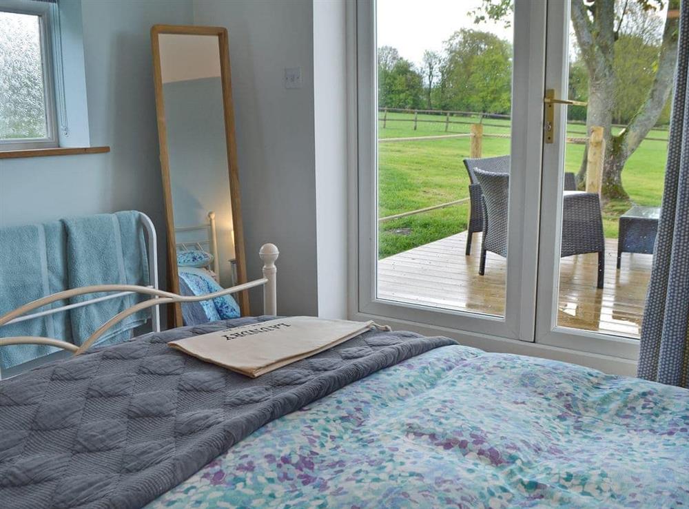 Bright and airy double bedroom with French doors leading to decked terrace (photo 2) at The Blue Loft in Playden, near Rye, East Sussex