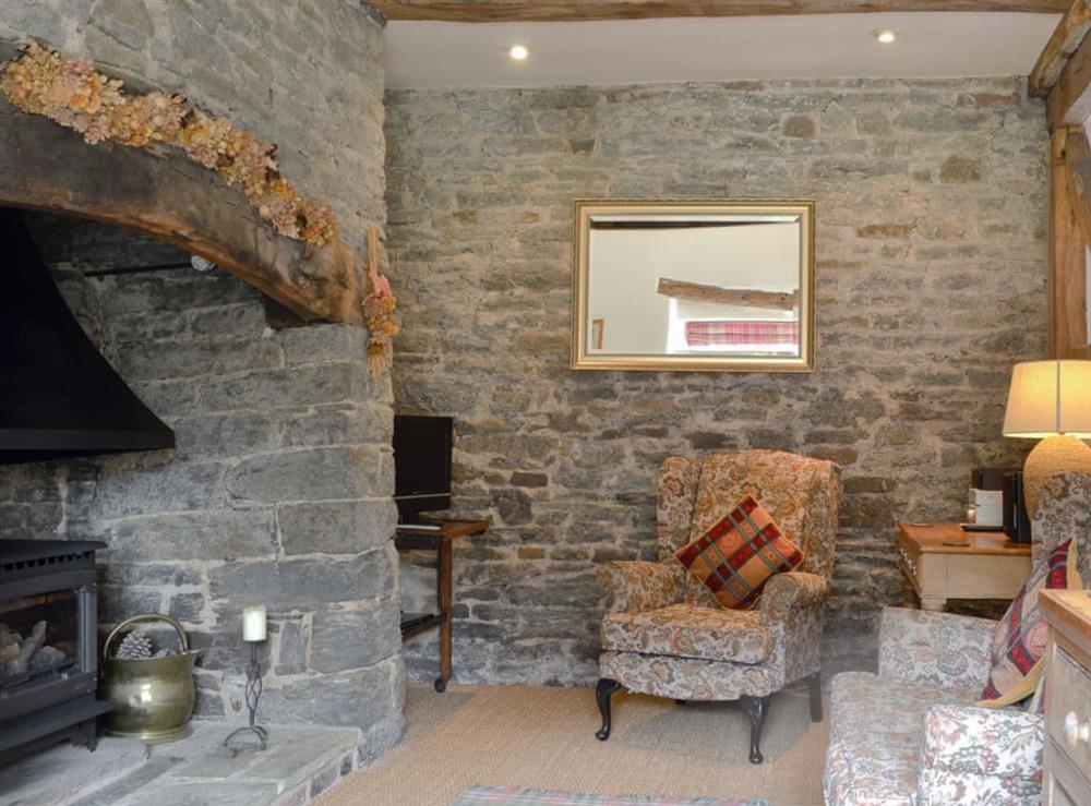 Living room with oak beams throughout and large inglenook fireplace at The Bothy in Bucknell, Shropshire