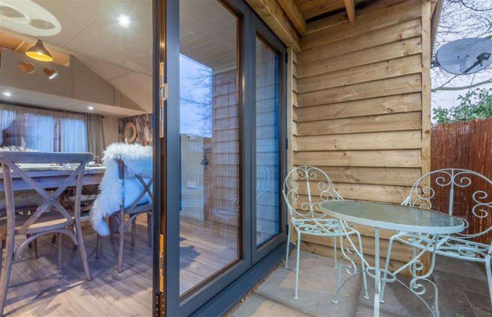 Bi-fold doors lead to the rear terrace with bistro table and chairs at The Bothy, Ringstead near Hunstanton