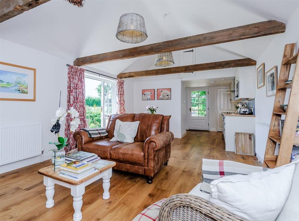 Open plan living space with wood flooring & exposed beams at The Bull Pen in Lawford, Essex, England