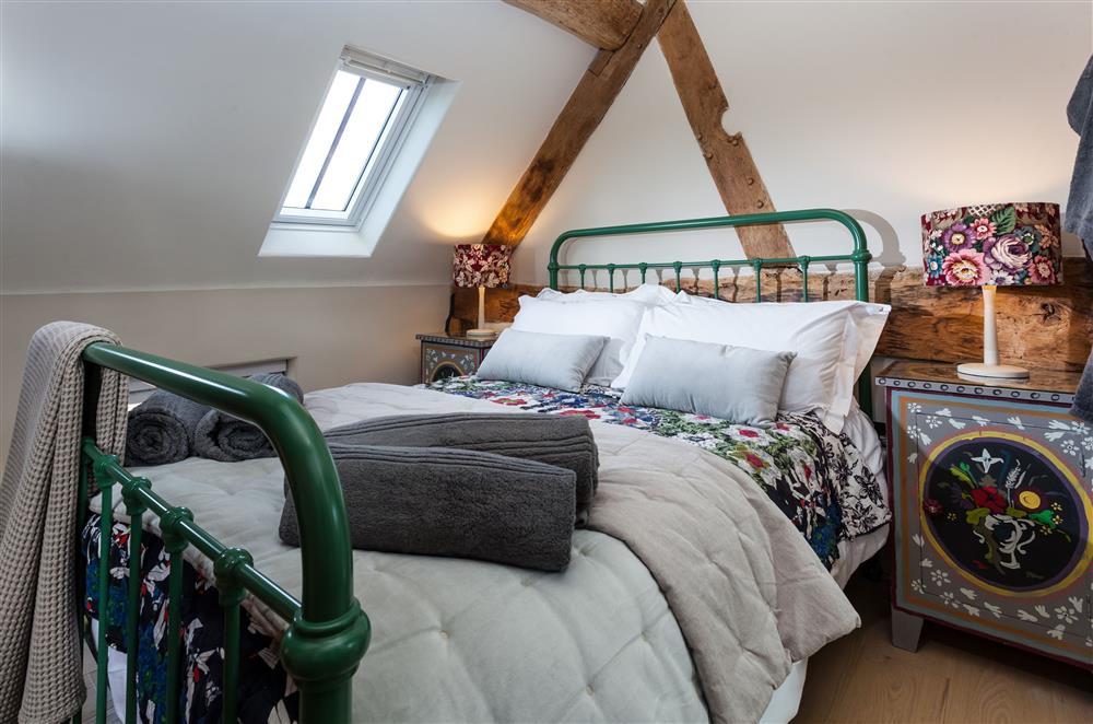 Bedroom one with a 4’6 double metal framed bed at The Byre, Bridgnorth
