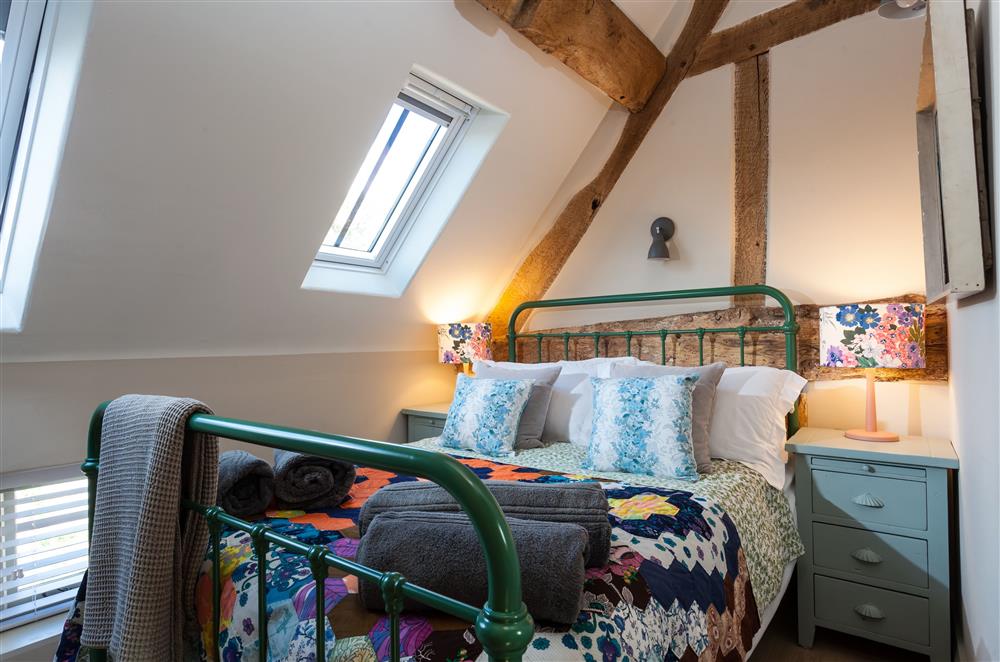 Bedroom three with a 4’6 double metal framed bed and en-suite bathroom at The Byre, Bridgnorth